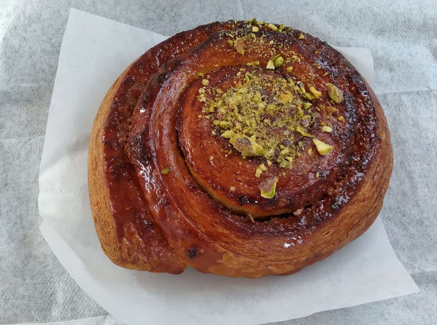 A pistachio-topped caramel morning bun at Artisana Bread in Houston, Texas