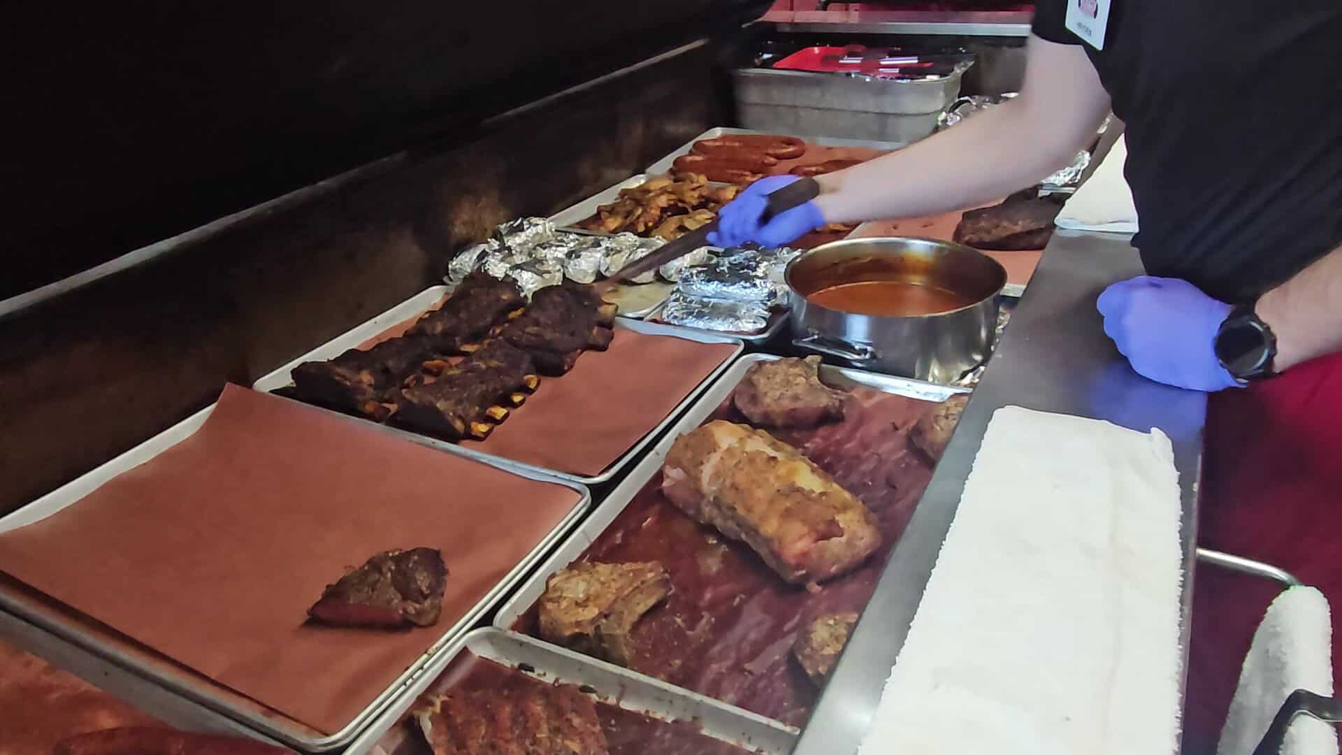 Pitmaster serving barbecue straight from the pit at Cooper's in Fort Worth
