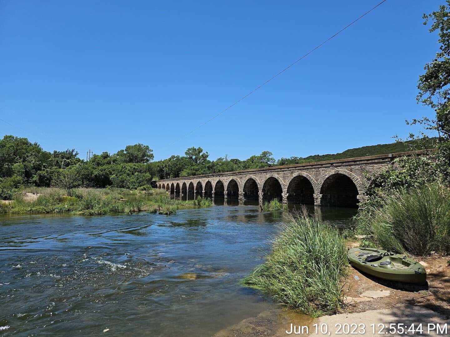 Long line of stone arches carrying Highway 16 across the Brazos River at the Possum Kingdom Stone Arch Bridge