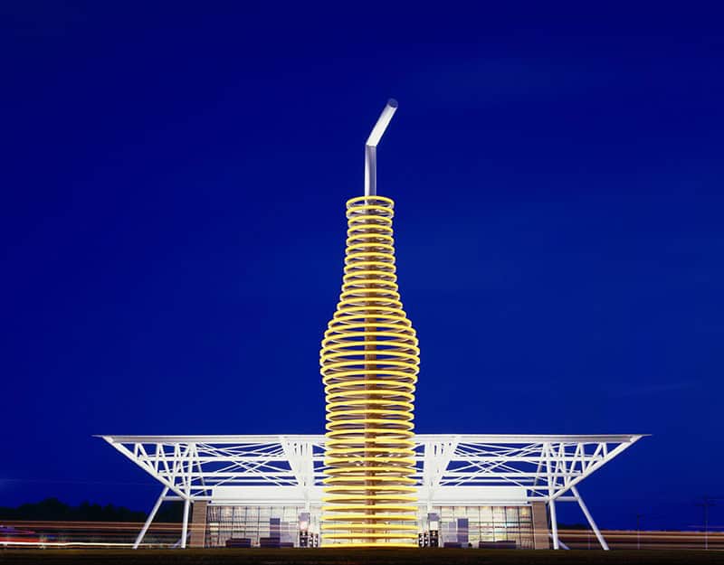 The 66-foot lit soda bottle at POPS 66 Soda Ranch in Arcadia, Oklahoma at dusk