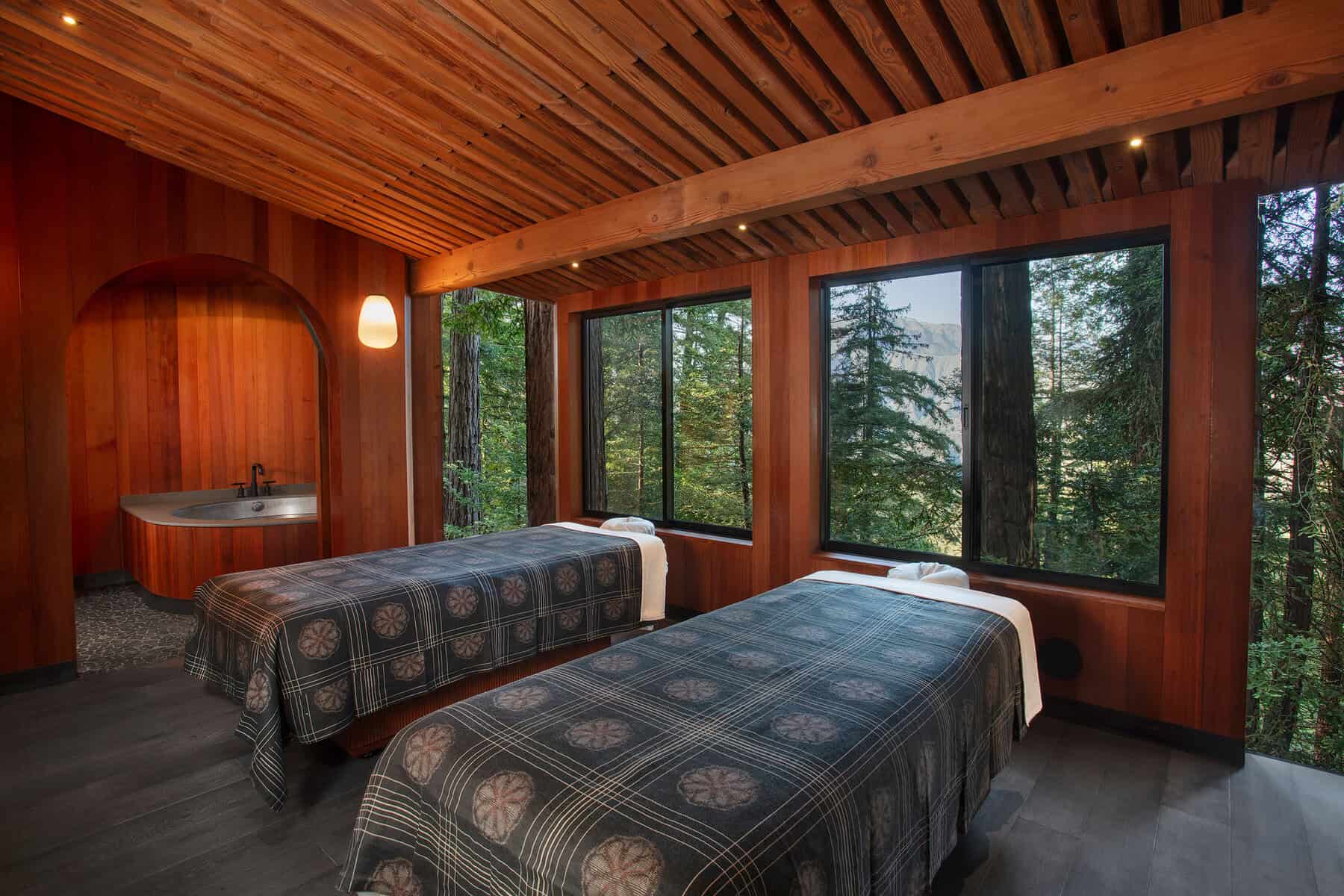 Warm wood-paneled treehouse room with forest windows at Post Ranch Inn in Big Sur, California