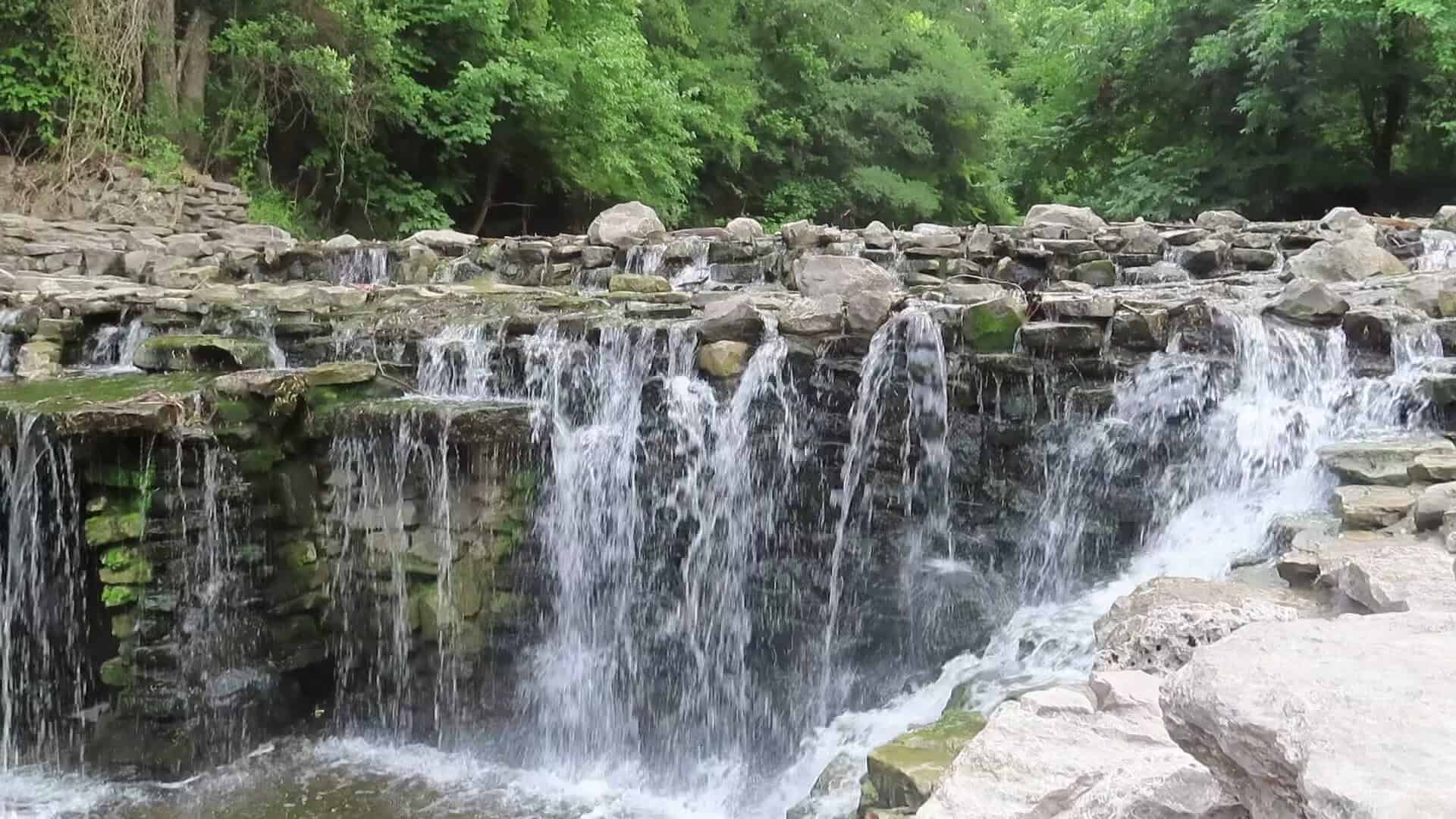 Prairie Creek Waterfall cascading over layered rock at Prairie Creek Park in Richardson, Texas