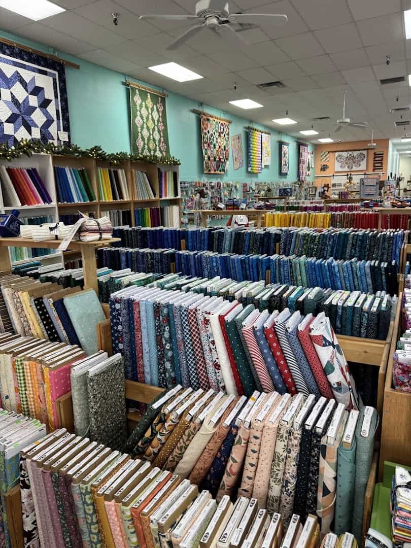 Deep aisles of quilting fabric bolts at Quilt Country in Lewisville, Texas