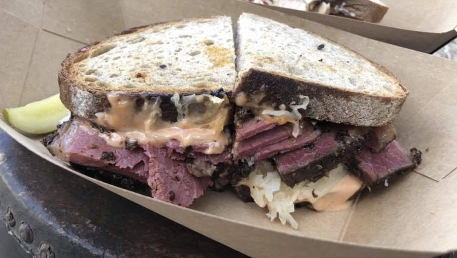 Pastrami Reuben half on marble rye with a pickle at Otherside Deli in Austin