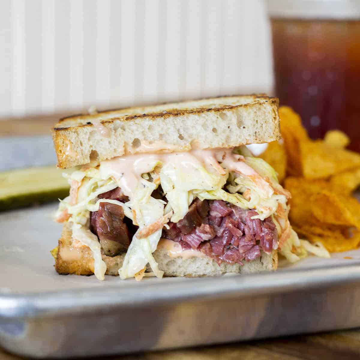 Reuben sandwich on a tray with chips at Otherside Deli in Austin