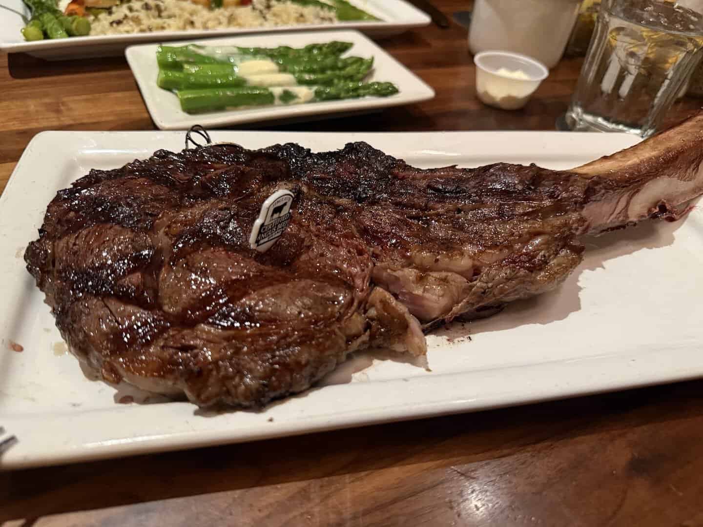 Grilled ribeye steak with asparagus on a plate at Taste of Texas in Houston