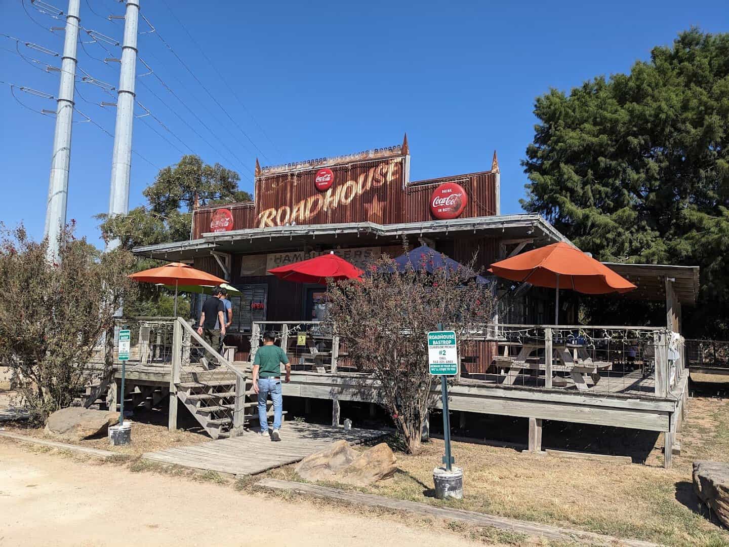 The Roadhouse building with patio umbrellas on Highway 21 in Bastrop, Texas