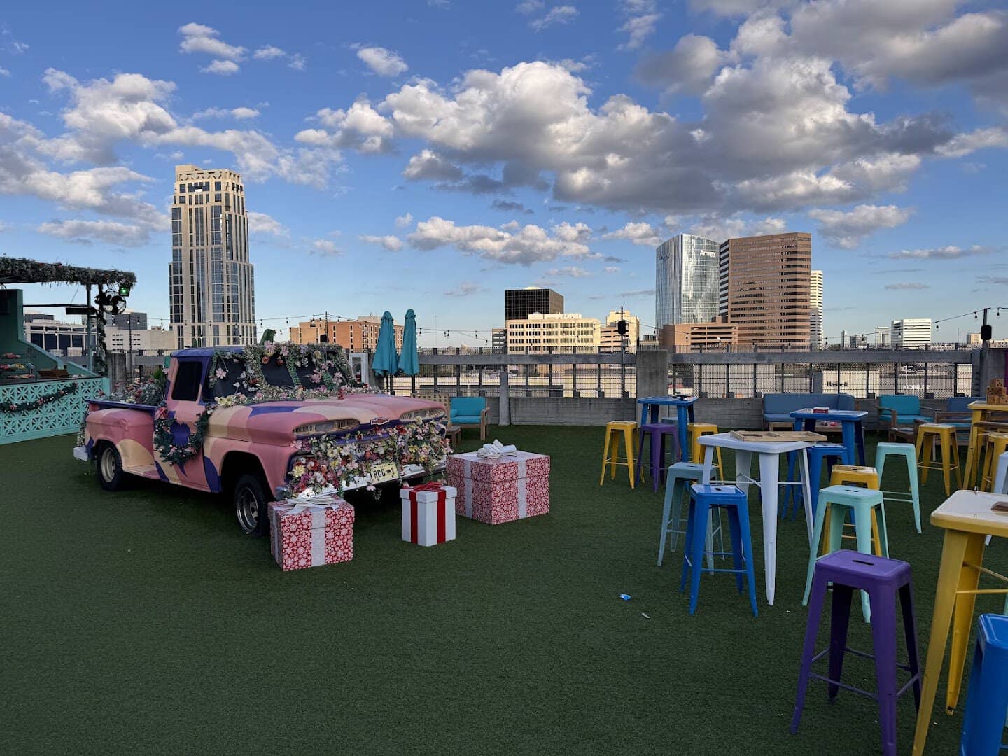 Decorated art car and rooftop seating with the Houston skyline at Rooftop Cinema Club Uptown