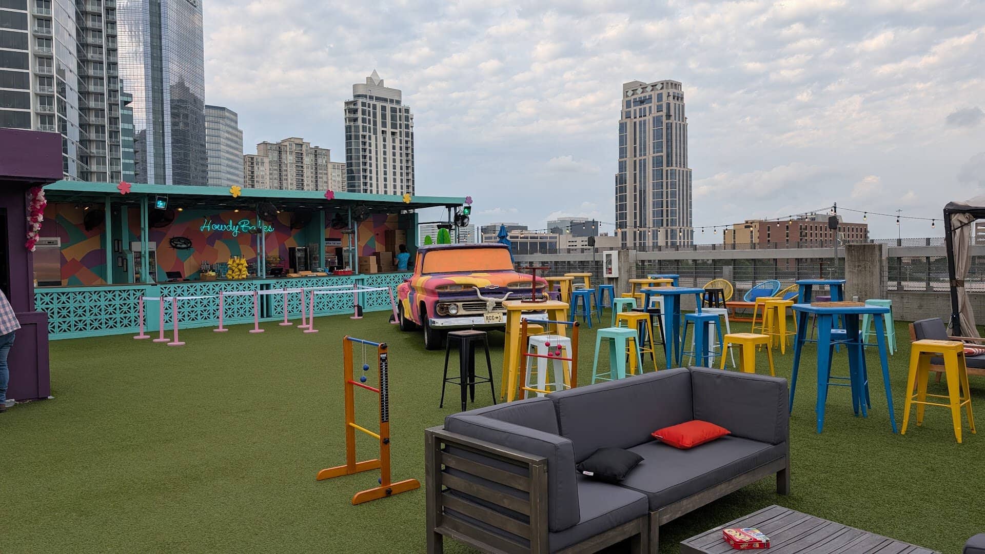 Rooftop lounge with couches and stools at Rooftop Cinema Club Uptown in Houston