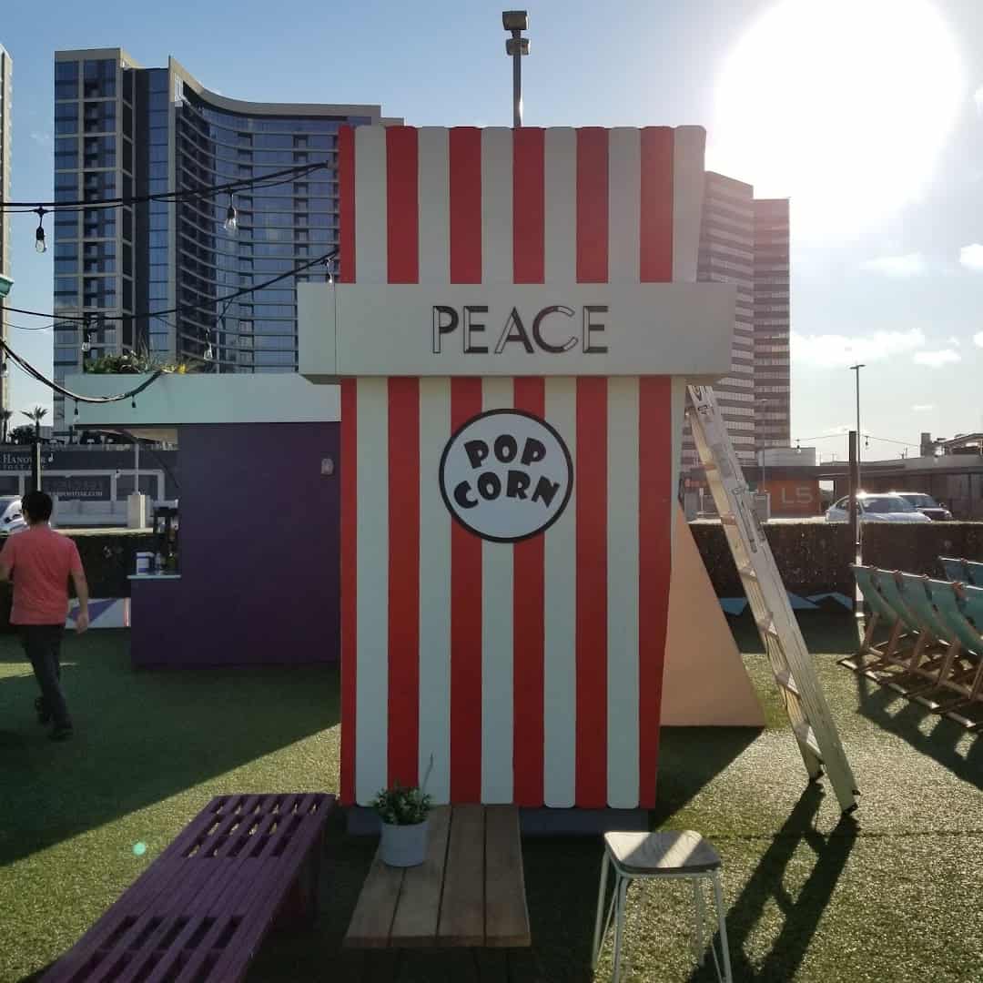 Striped popcorn concession stand with the Houston skyline behind it at Rooftop Cinema Club Uptown