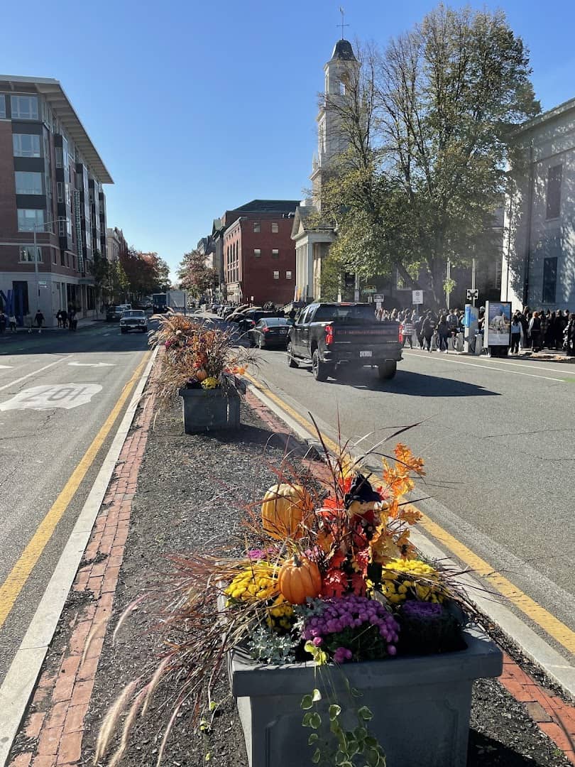 Autumn pumpkin and mum planter on a brick street in Salem, Massachusetts in fall