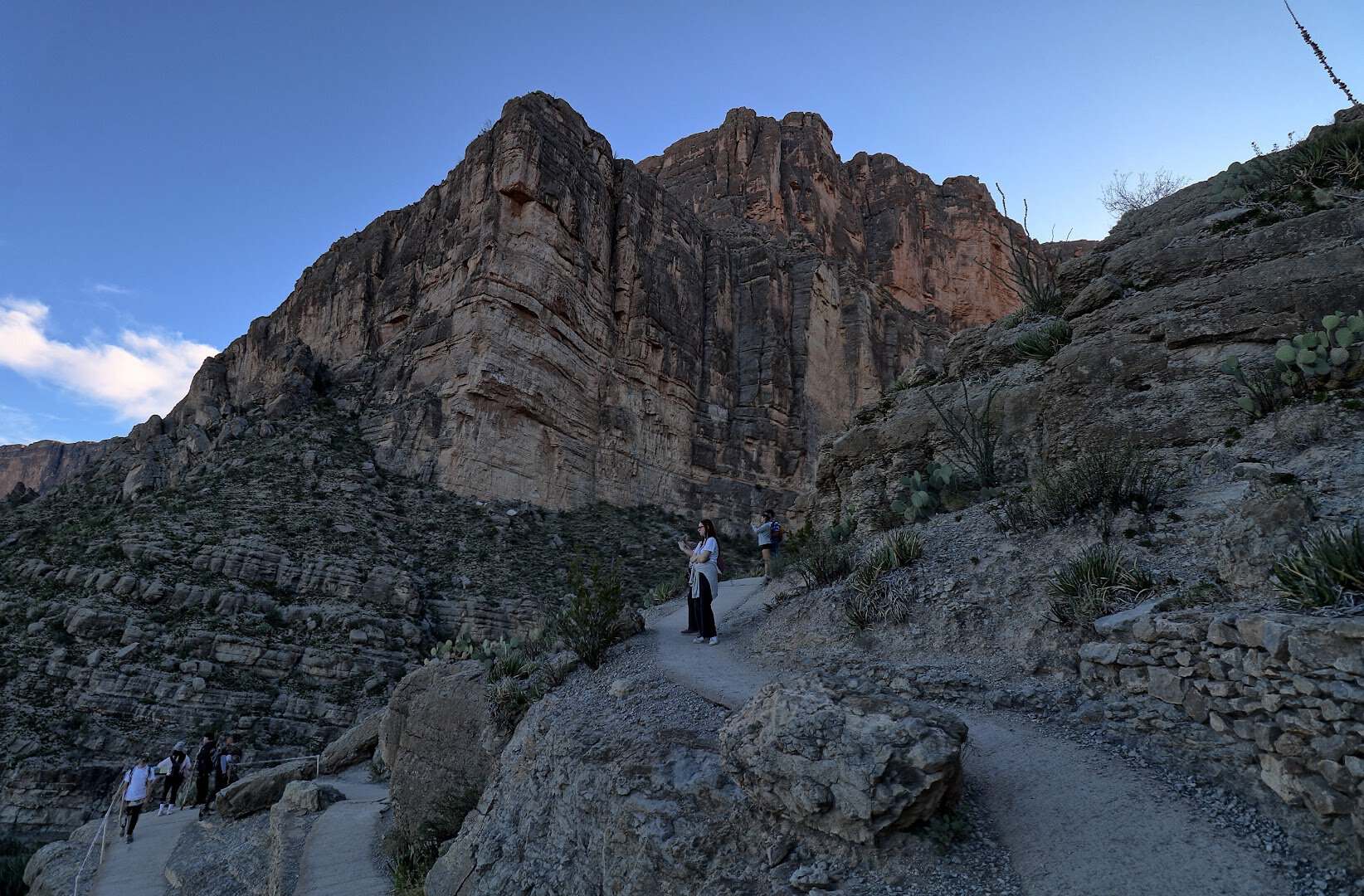 Hikers on the Santa Elena Canyon Trail below towering cliffs in Big Bend National Park