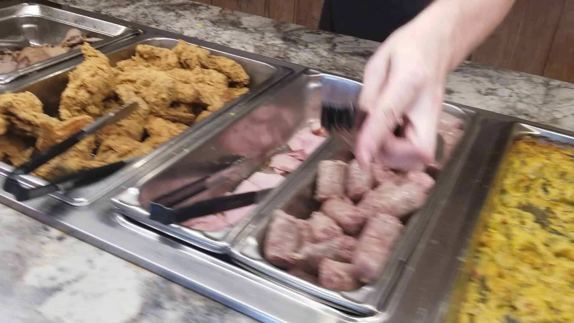 Buffet trays of fried chicken tenders, sliced ham and sausage at Schobels' Restaurant in Columbus, Texas