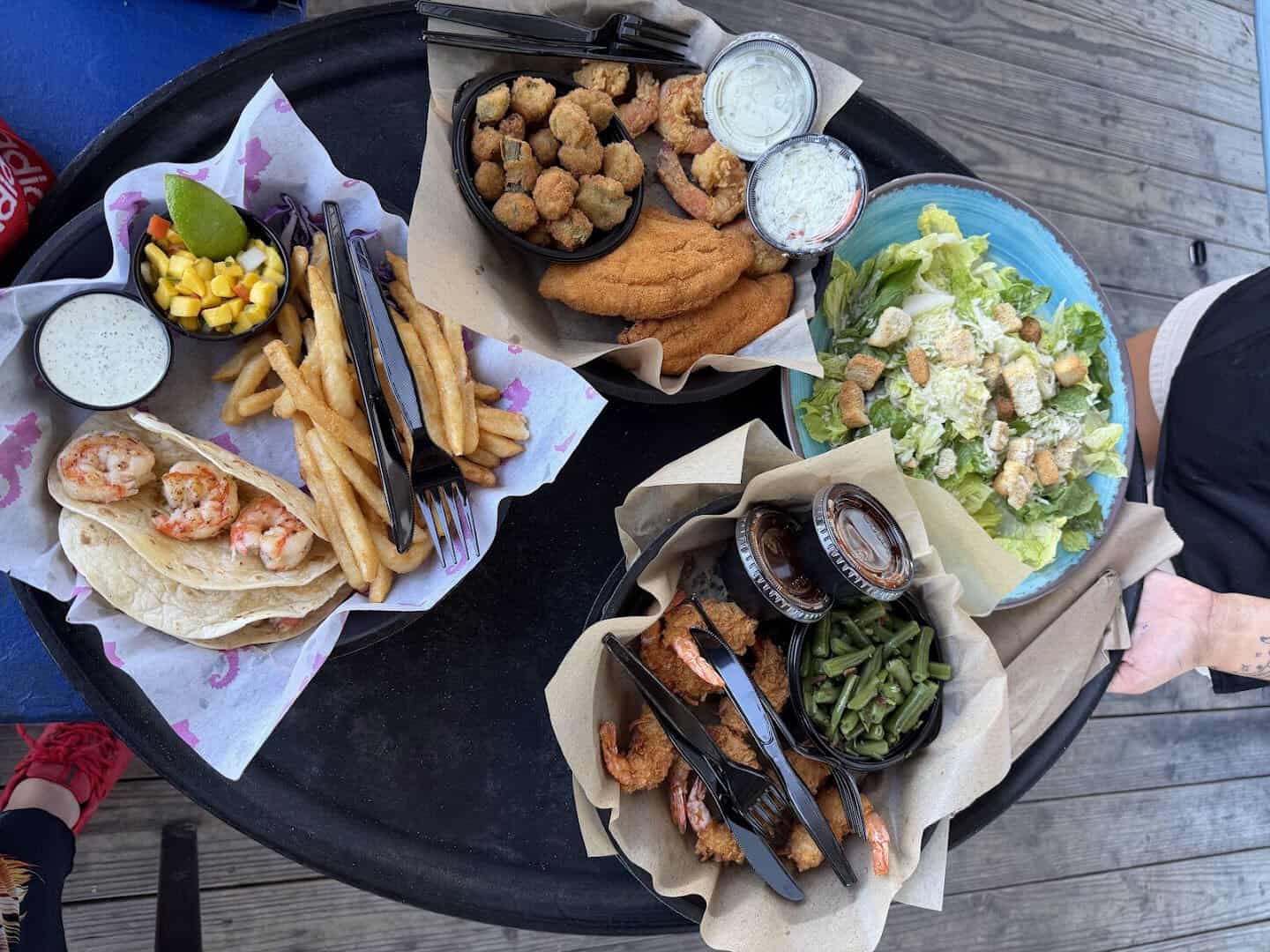 Shared spread of Gulf seafood, shrimp tacos and sides at Seahorse Bar & Grill in Surfside Beach, Texas