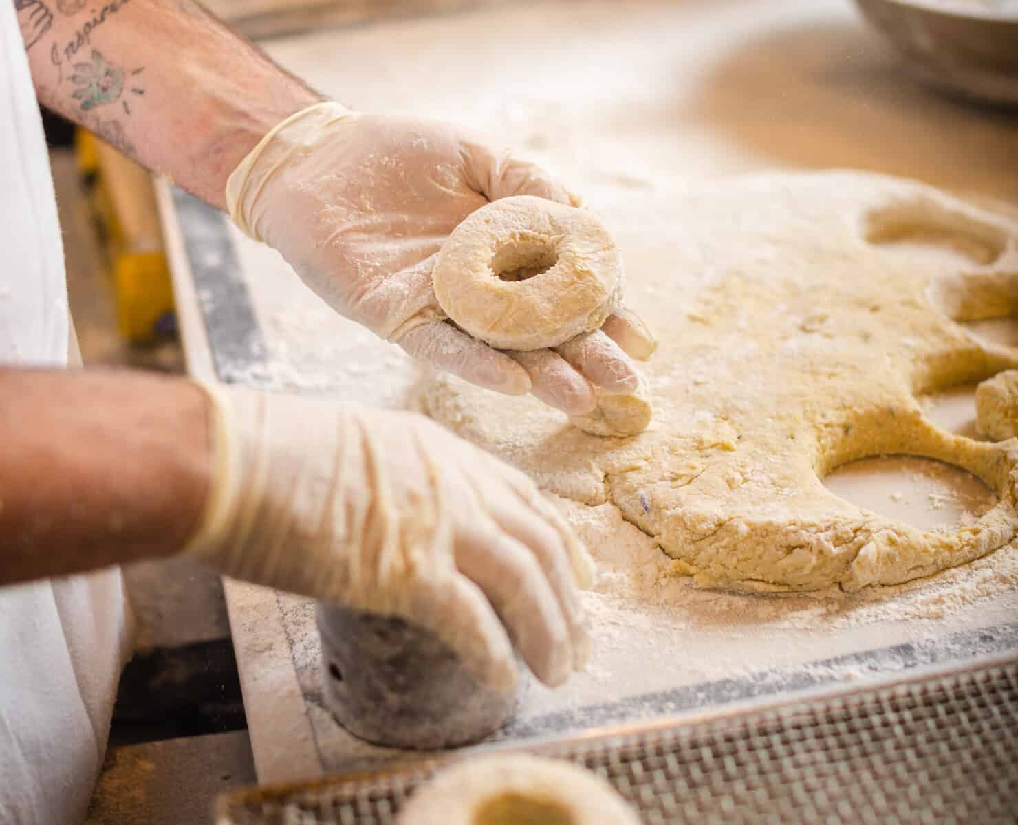 Hand-shaping fresh dough at Sidecar Doughnuts in Costa Mesa, California