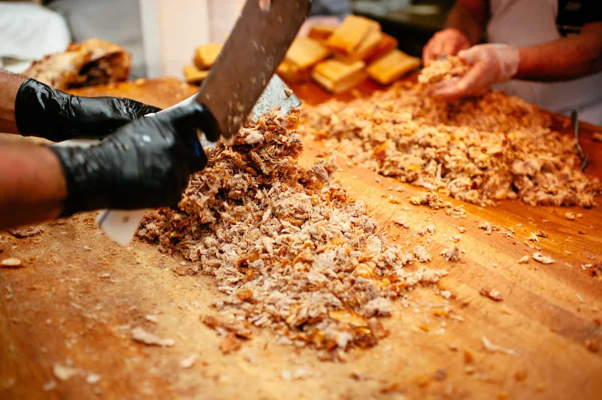 Pitmaster chopping whole hog pork at Skylight Inn BBQ in Ayden, North Carolina