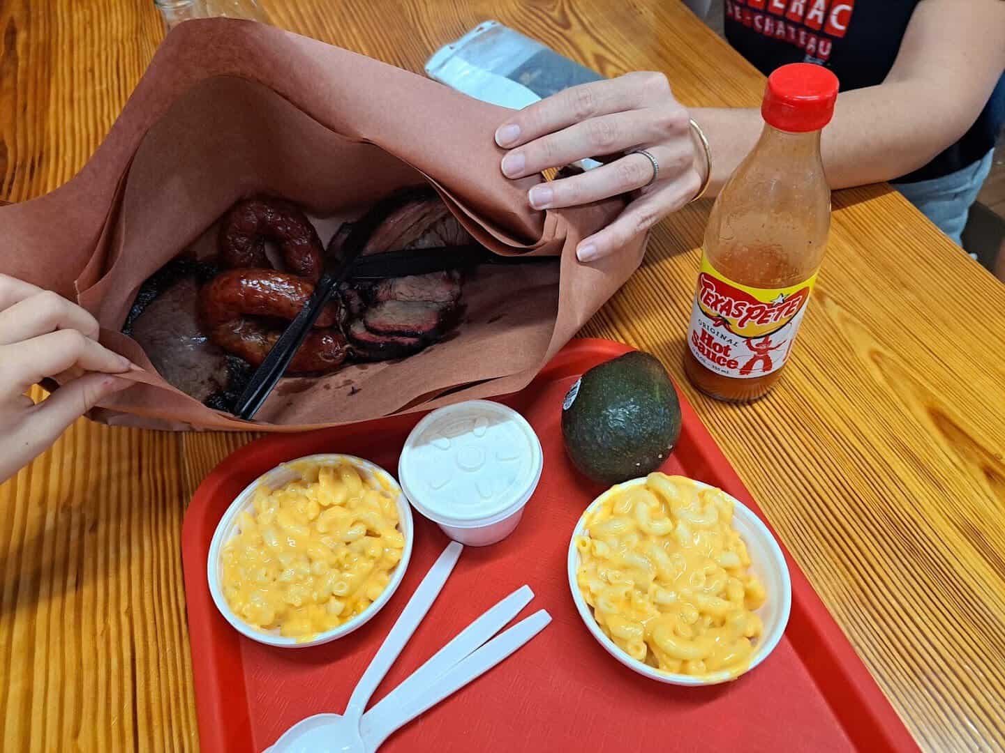Sliced brisket and sausage tray with hot sauce at Smitty's Market in Lockhart, Texas