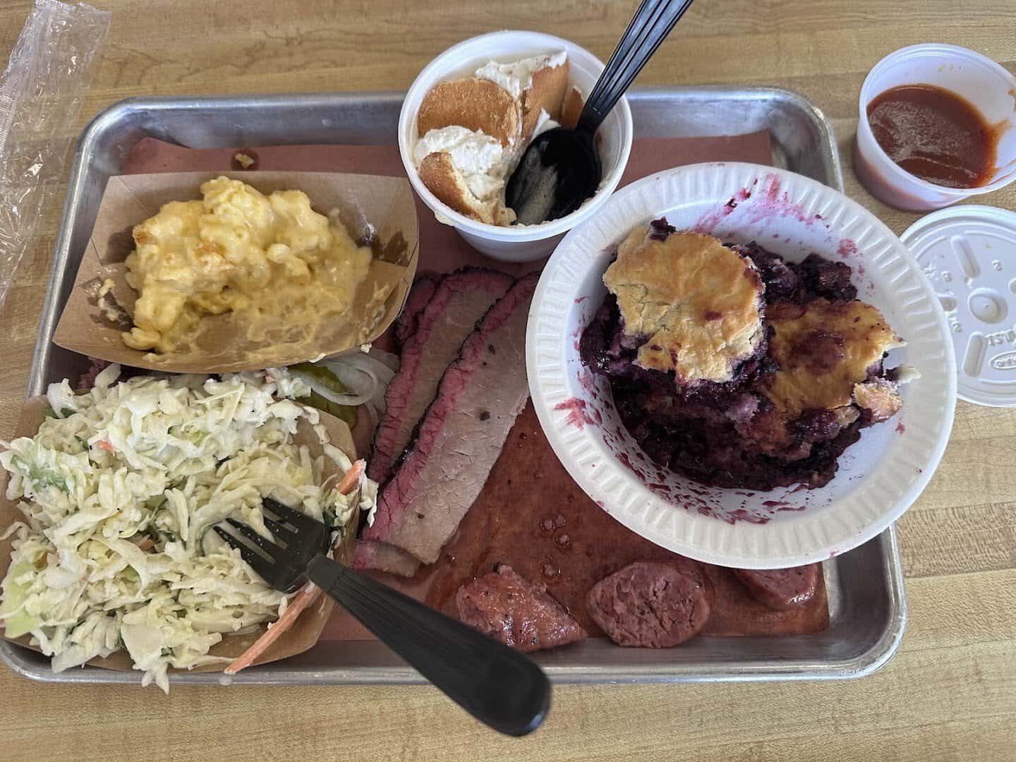 Barbecue spread with brisket, sausage, sides and peach cobbler at Southside Market and Barbeque in Elgin, Texas