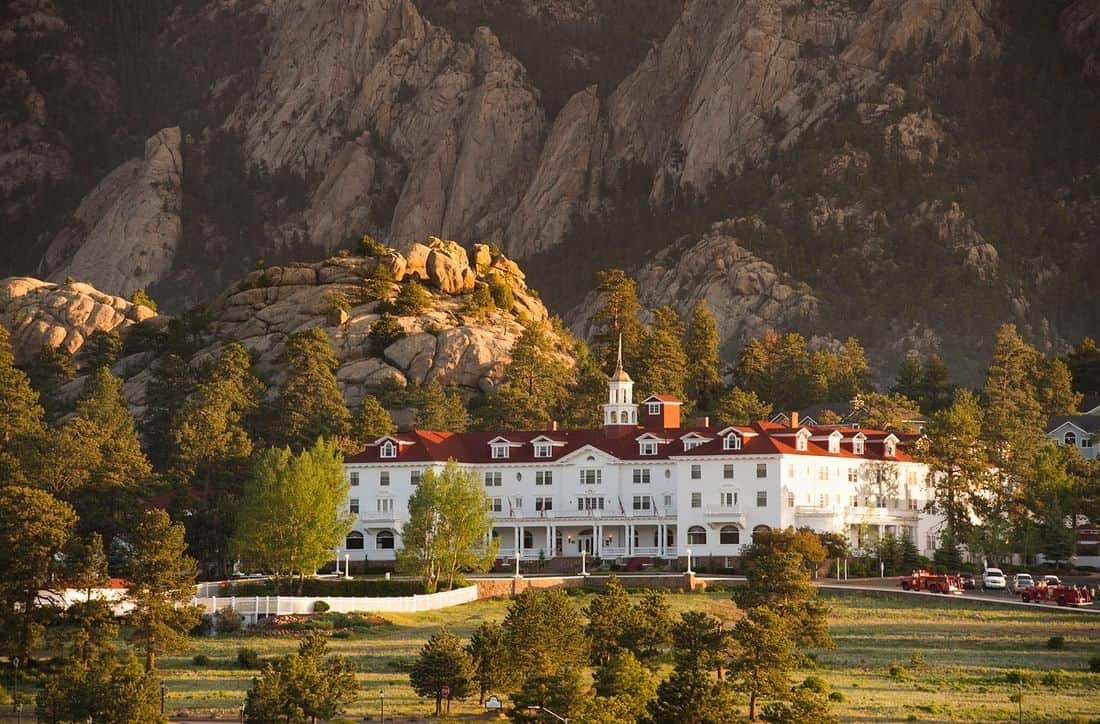 The Stanley Hotel exterior with Rocky Mountains behind it in Estes Park, Colorado