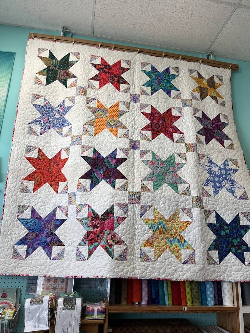A pieced star sampler quilt hanging at Quilt Country in Lewisville, Texas