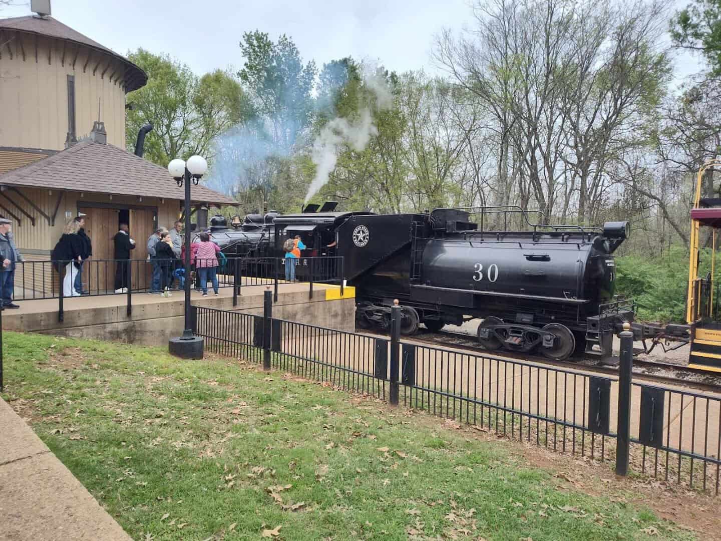 Steam locomotive at the Texas State Railroad depot amid fresh spring greenery