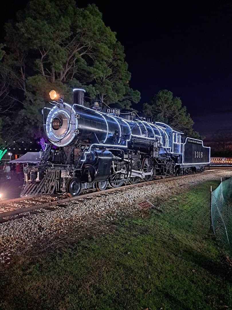 Restored steam locomotive of the Texas State Railroad lit up at the depot