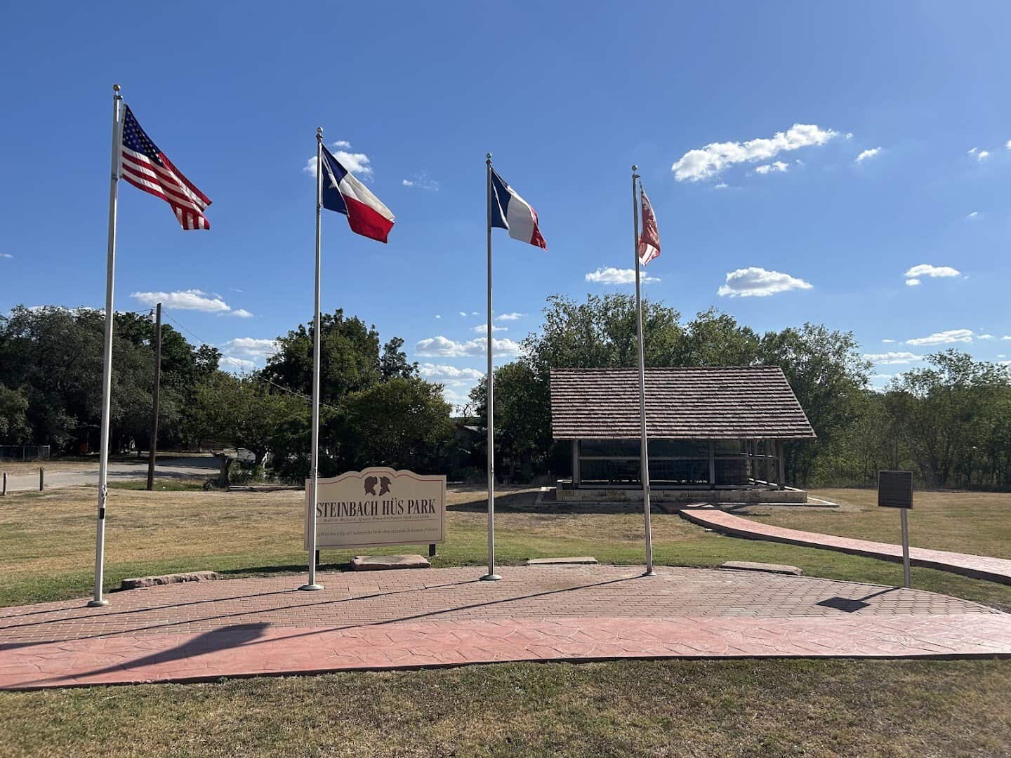 Flags of the US, Texas, France and Alsace at Steinbach Hus Park in Castroville, Texas