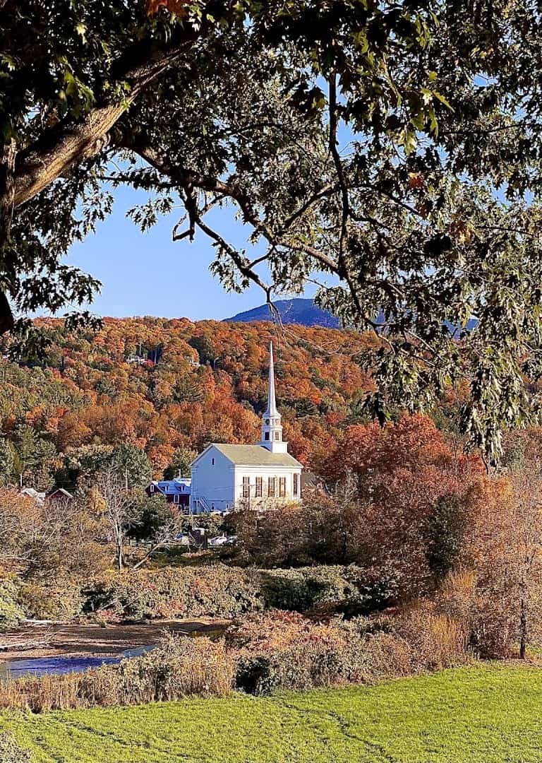 Stowe Community Church framed by autumn foliage in Stowe, Vermont in fall