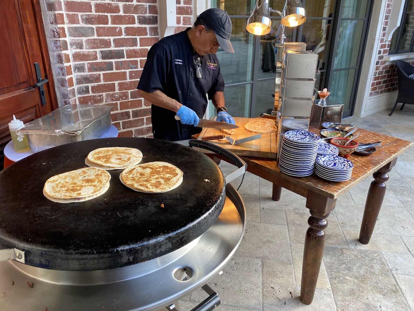 Cook grilling street tacos outside on the barbecue pit at Mi Familia at the Rim in San Antonio