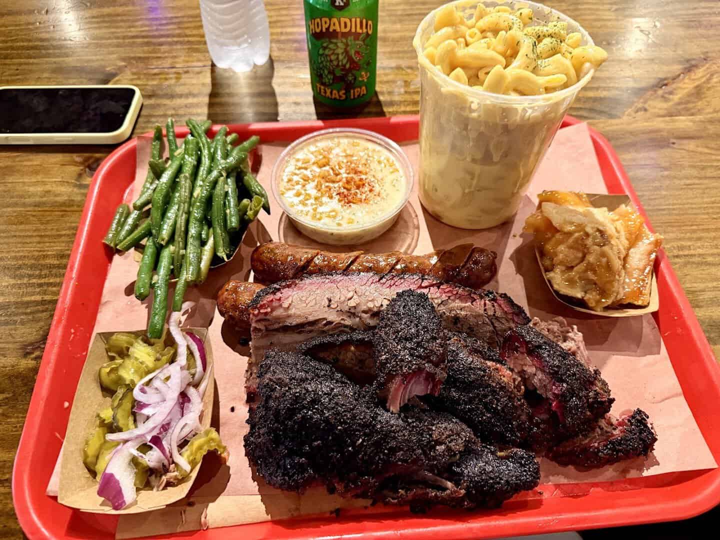 Tray of smoked beef ribs with mac and cheese and green beans at Terry Black's Barbecue in Austin, Texas