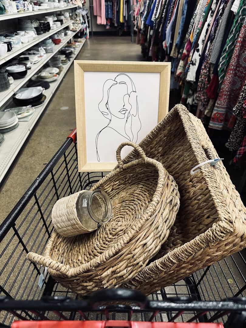Shopping cart filled with framed art and baskets at Thrift Giant in Dallas