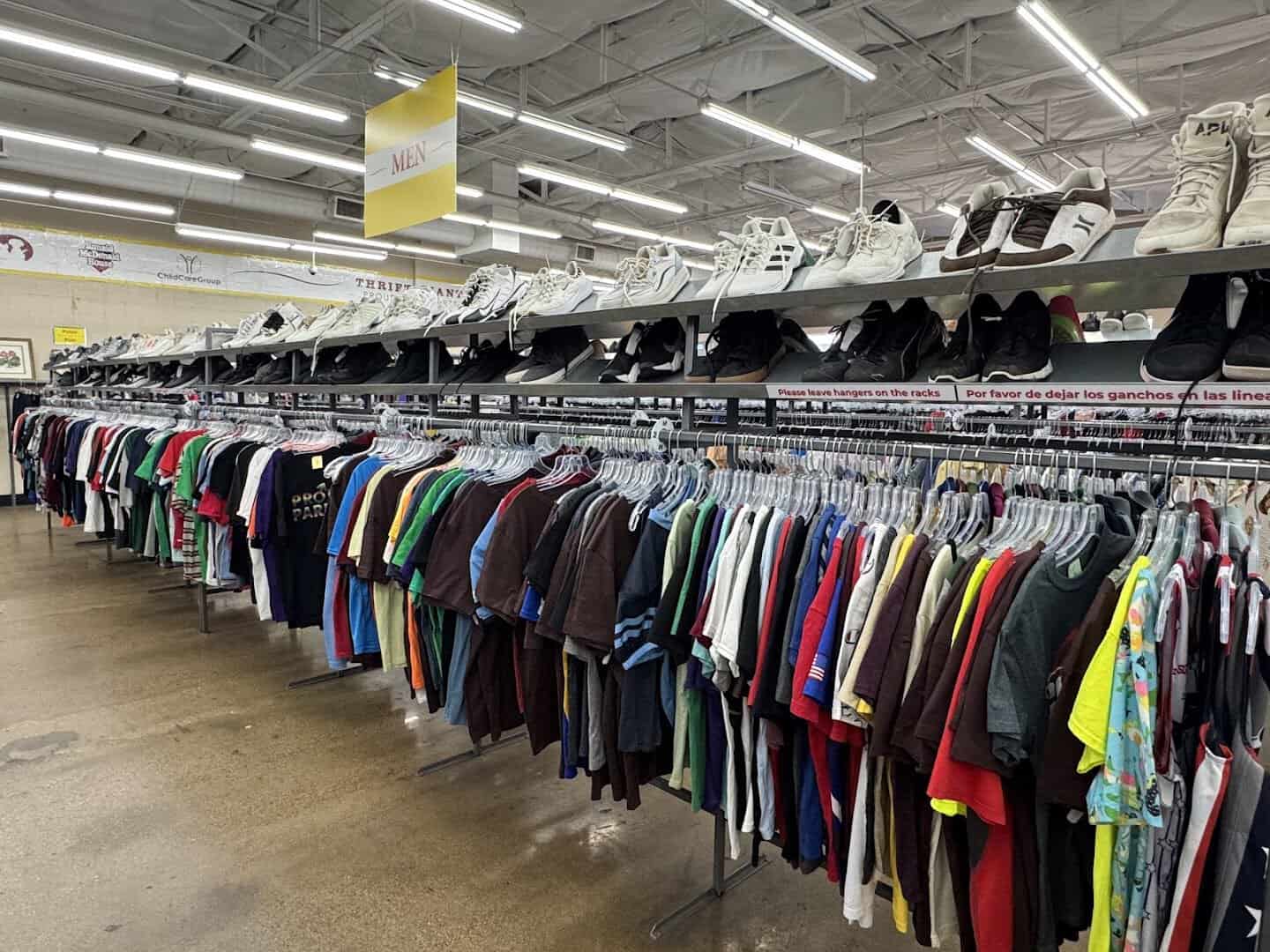 Long aisle of clothing racks at Thrift Giant in Dallas
