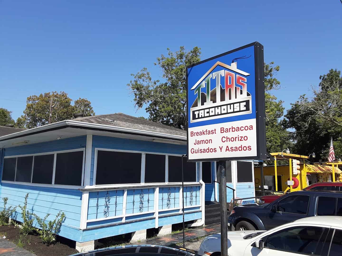 The bright blue exterior and sign of Titas Taco House in Humble, Texas