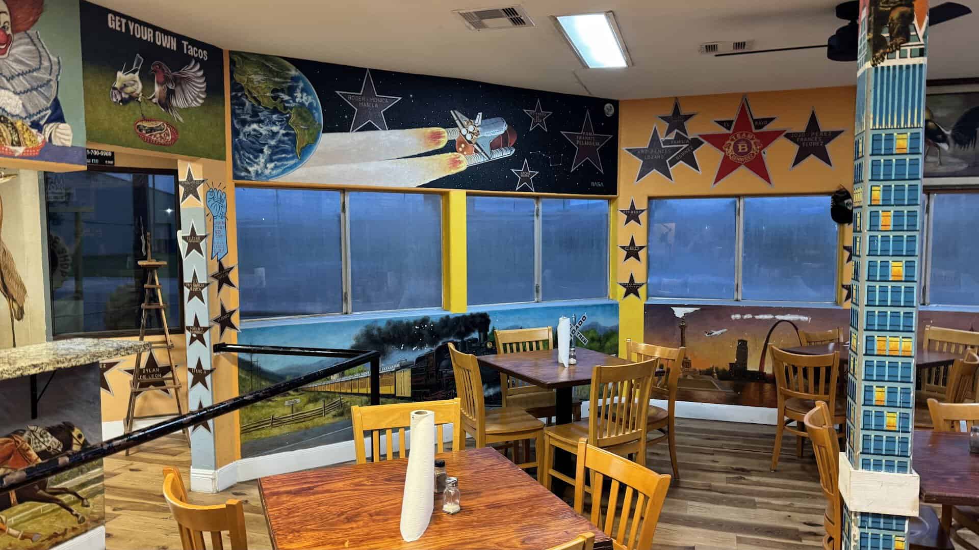 A colorful space-themed mural wall inside Titas Taco House in Humble, Texas