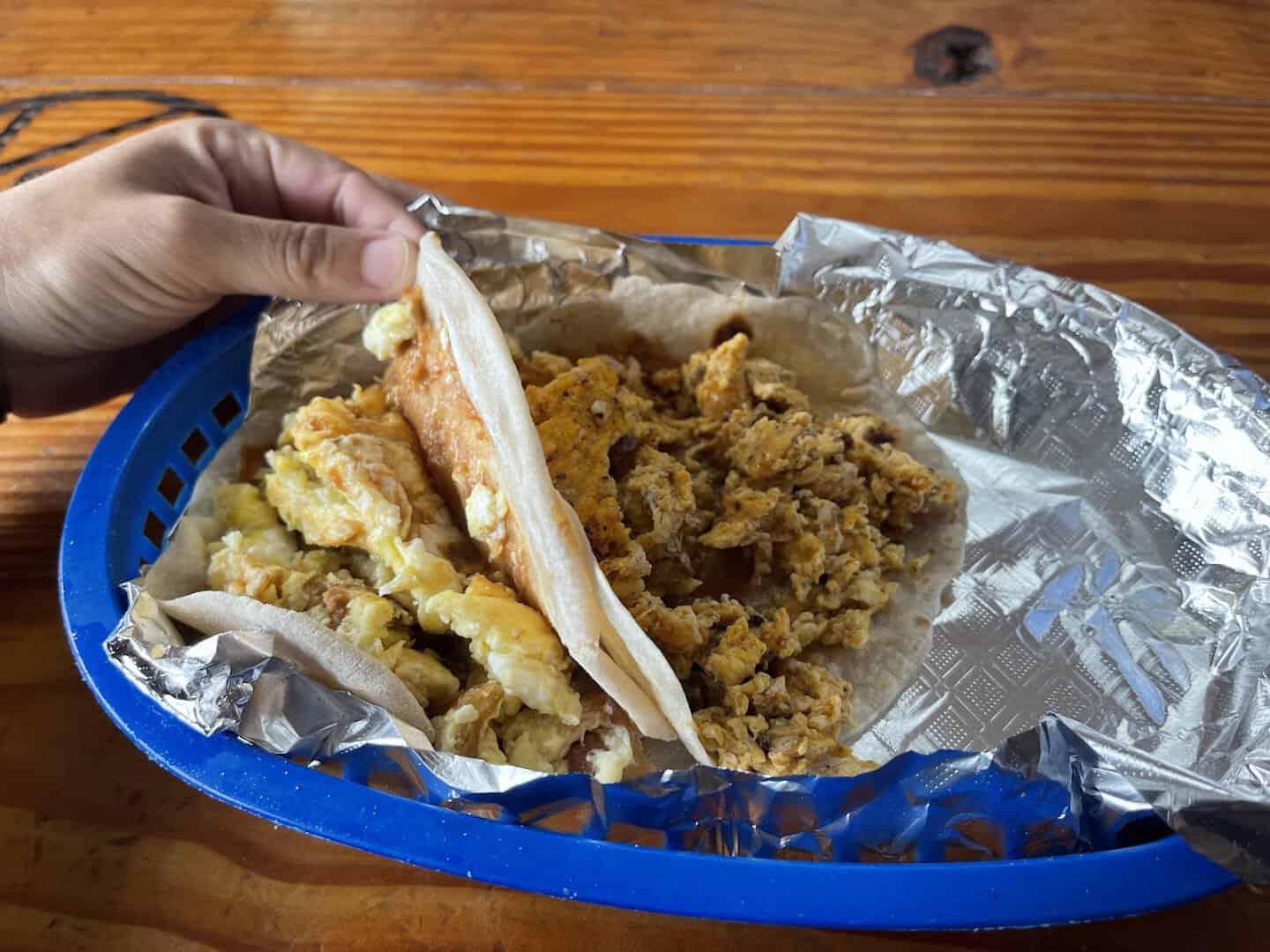 An open barbacoa breakfast taco at Titas Taco House in Humble, Texas
