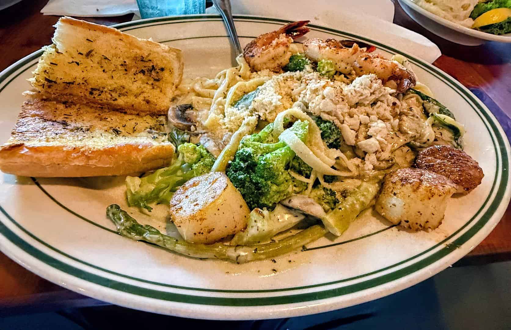 Seafood pasta with shrimp, scallops and garlic bread at Topwater Grill in San Leon