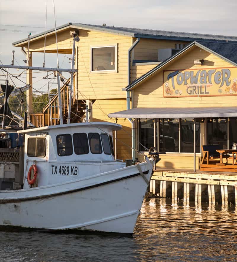Topwater Grill's shrimp boat docked beside the restaurant on Galveston Bay