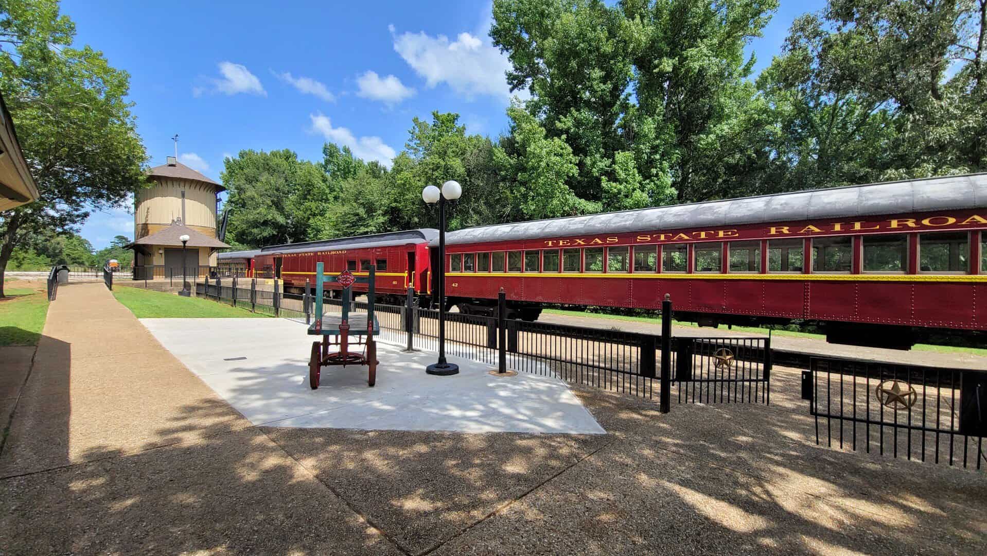 Texas State Railroad train waiting at the sunny depot platform