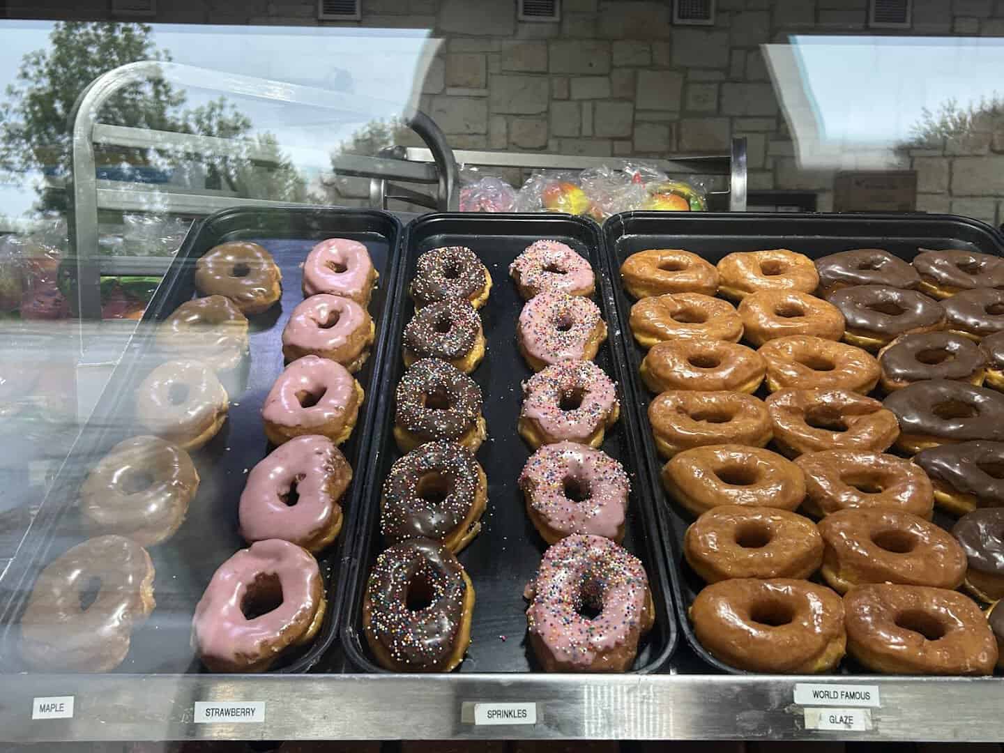 Trays of freshly glazed and strawberry donuts at Round Rock Donuts in Round Rock, Texas