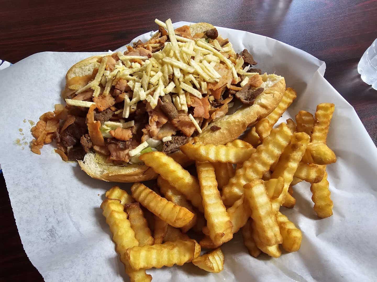 Tripleta sandwich piled with meat and crinkle fries at El Flamboyan in Wylie, Texas