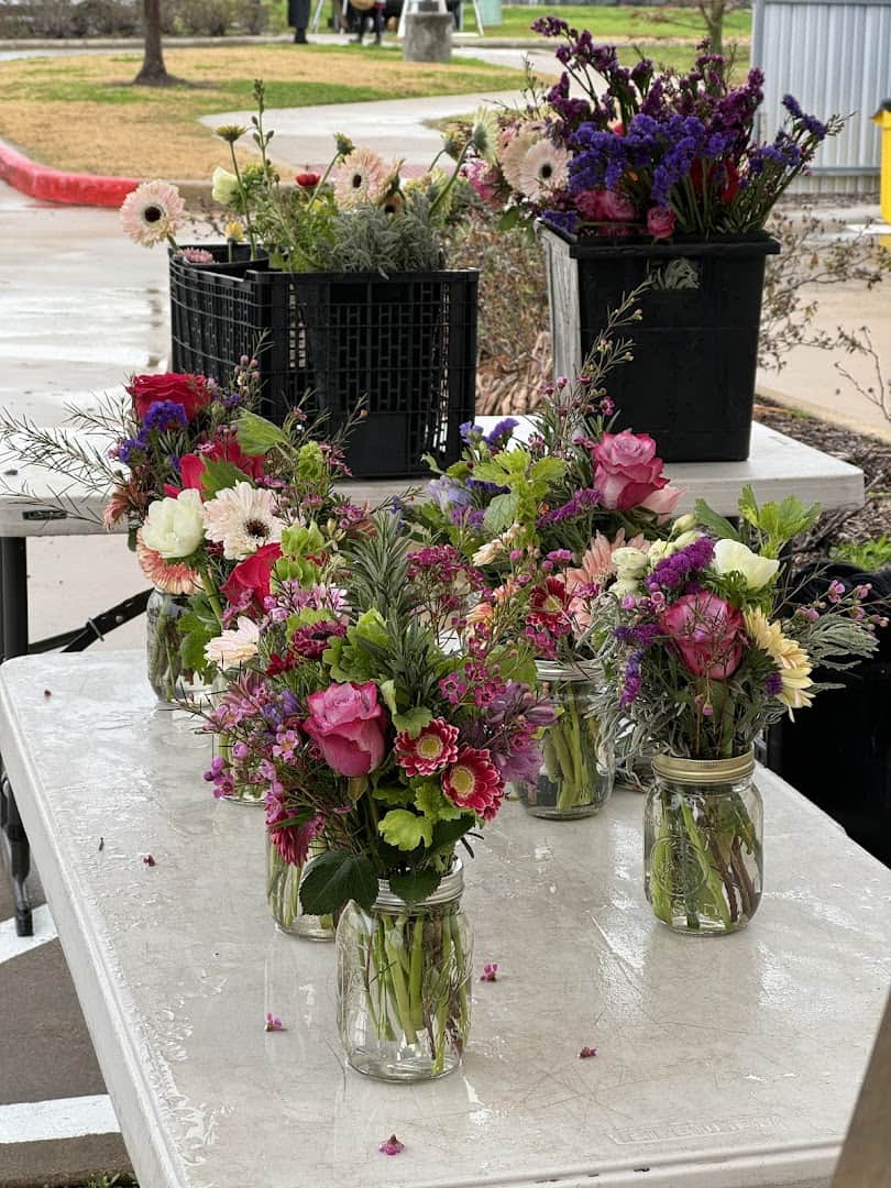 Buckets of fresh cut flowers in jars at Urban Harvest Farmers Market in Houston