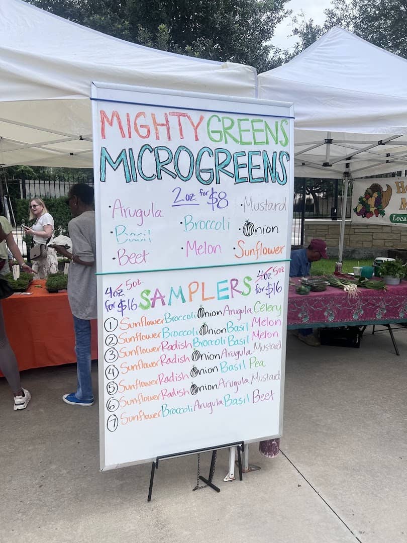 Microgreens vendor stall with a handwritten sampler menu at Urban Harvest Farmers Market