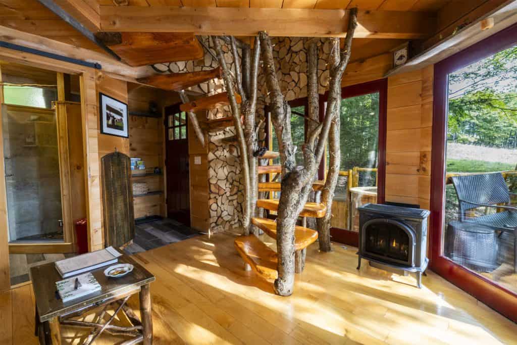 Treehouse interior with tree trunk and spiral stair at Vermont Tree Cabin in Coventry, Vermont
