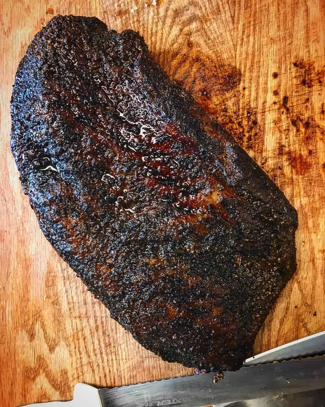 Smoked brisket on a wooden cutting board at Victorian's Barbecue in Mart, Texas