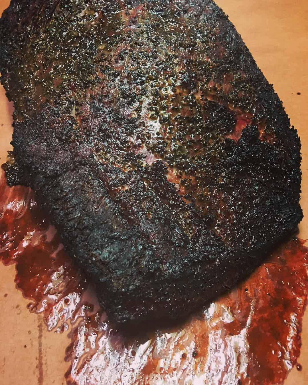 Sliced smoked brisket served with sauce at Victorian's Barbecue in Mart, Texas