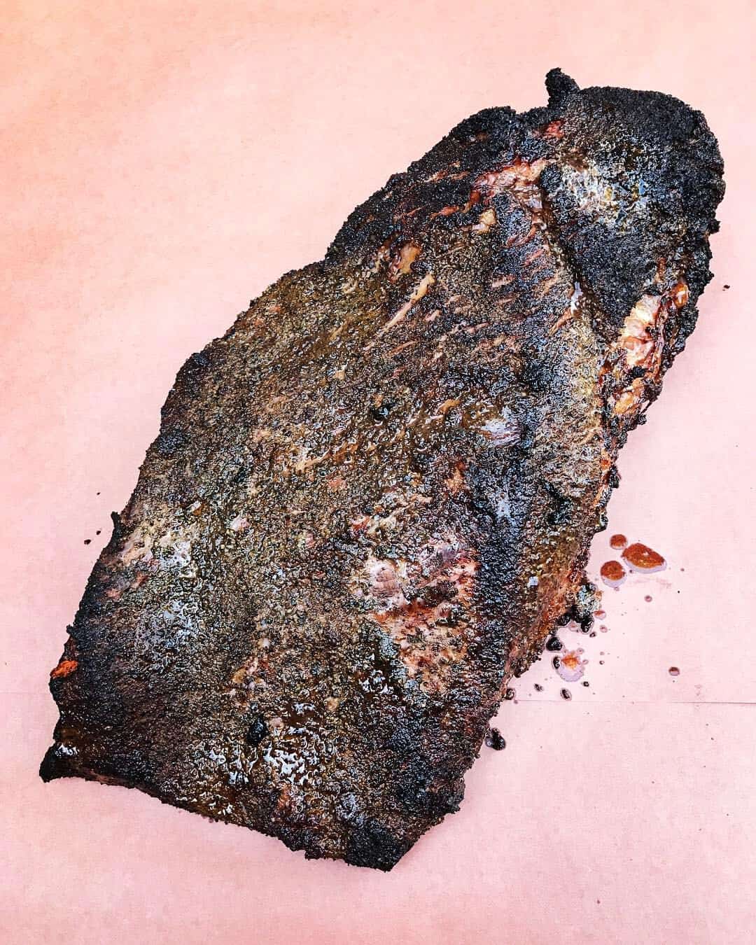 Whole smoked brisket resting on butcher paper at Victorian's Barbecue in Mart, Texas