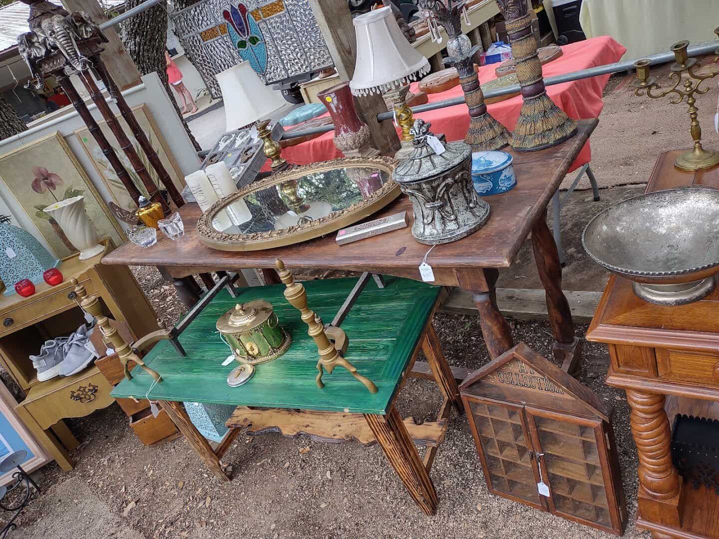 Table of vintage glassware, lamps and cast iron at Wimberley Market Days