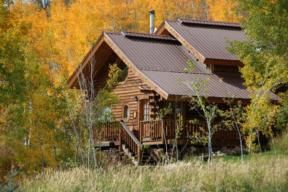 Log cabin among golden aspens at Vista Verde Ranch near Steamboat Springs, Colorado