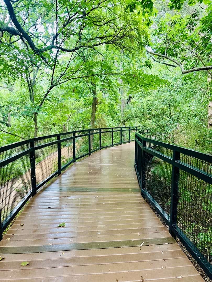 Wooden footbridge over the creek on the trail at Prairie Creek Park in Richardson, Texas