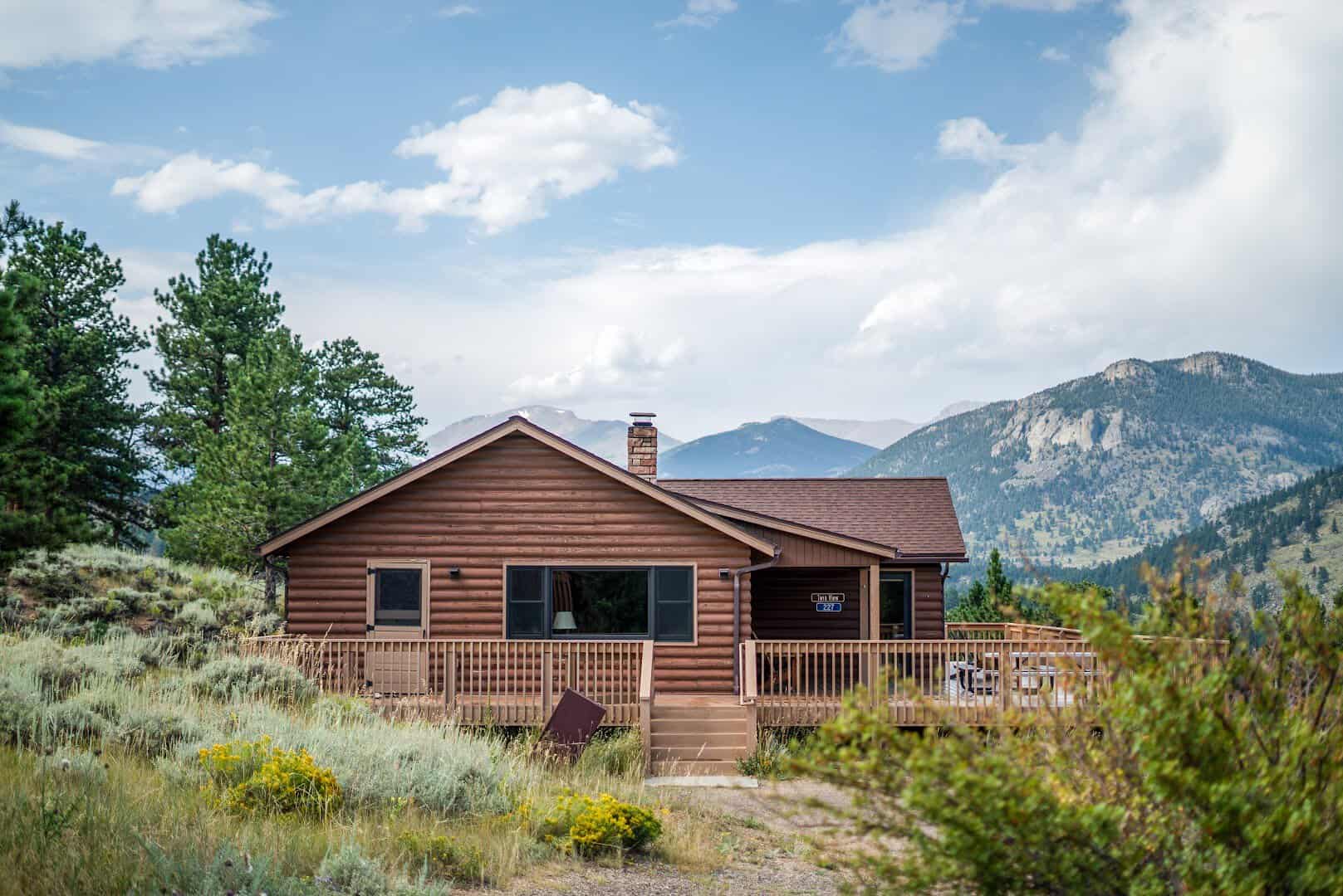 Log cabin below snow-capped peaks at YMCA of the Rockies in Estes Park, Colorado